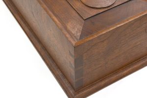 The corner of a document box with top molded edge that is mitered above its dovetails.