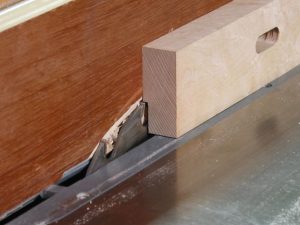 Use a flat top, rip blade to make the rabbet in the fence for the brass rub strip.