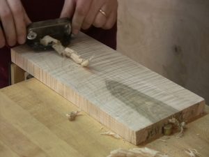 A cabinet scraper in many ways is more akin to a plane, in that it pulls a thicker shaving.