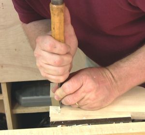 Using the back of the chisel as a guide to pare the shoulder cut on a tenon.