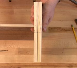 In the example, the two drawer sides are held together and a triangle is drawn on the top edge, the left half on the left side and the right on the right.