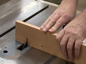 Use a scrap as an auxiliary fence to make the box joint jig. 